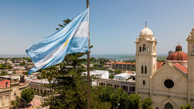 Argentinian flag waving in the wind against a blue sky, Victoria city, Entre Rios, Argentina